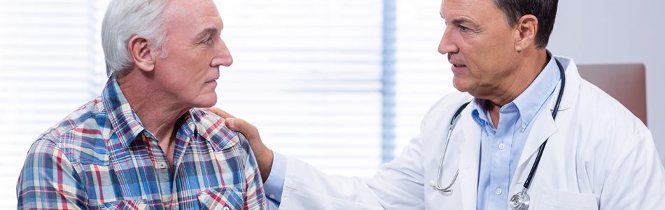 Doctor consoling senior man in clinic