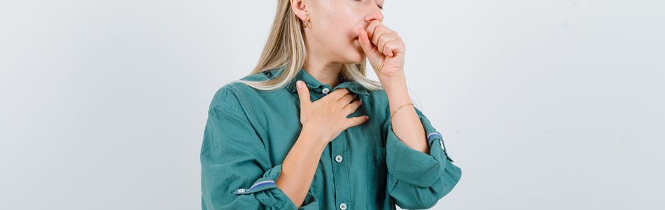 young lady in green shirt suffering from cough and looking sick , front view.